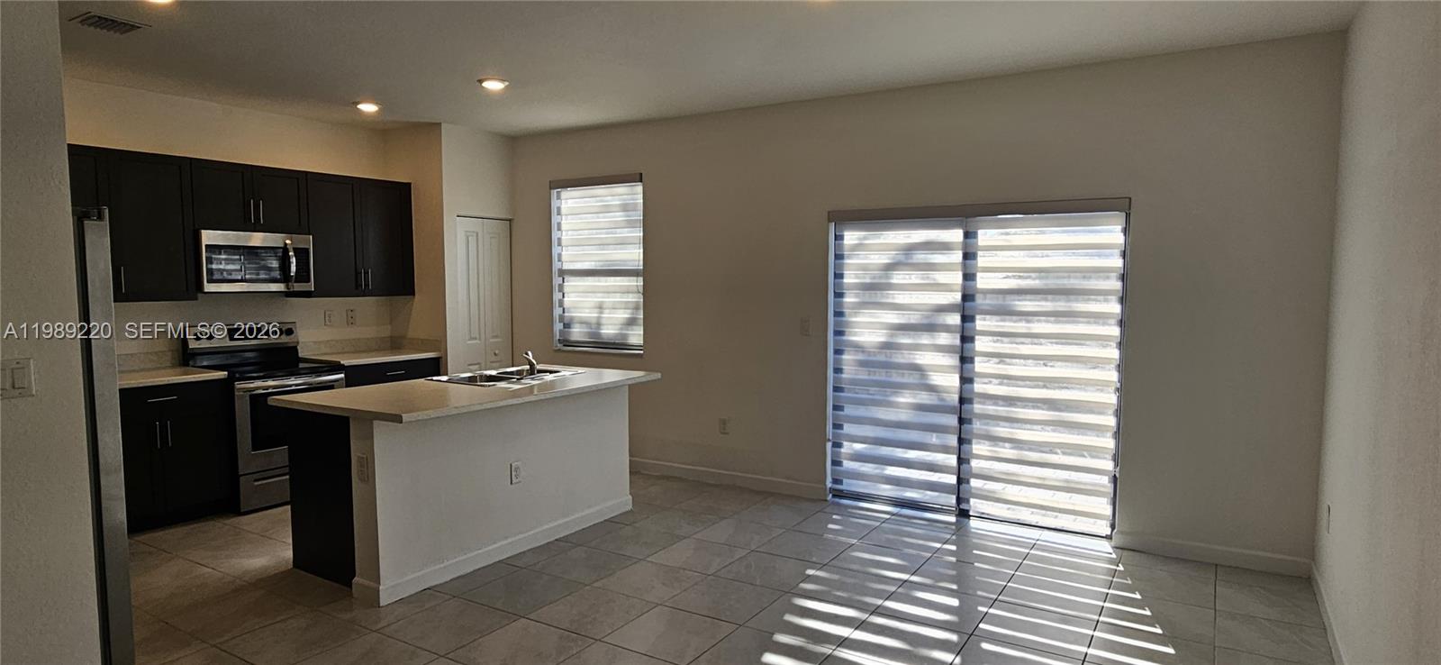 28708 Southwest 134th Court Homestead, FL 33033 - Photo 5 of 26 a kitchen with granite countertop a sink and a stove top oven
