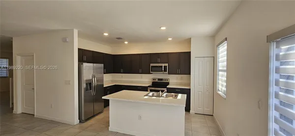 a living room with a couch and a refrigerator