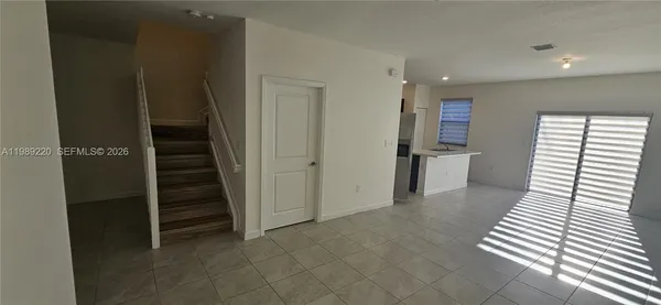 a view of a hallway with entryway and wooden floor