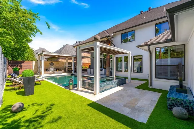 a view of a house with a yard patio and swimming pool