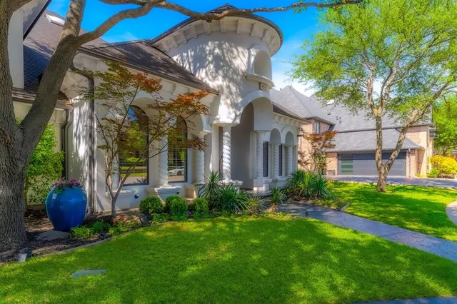 a view of a house with brick walls and a large tree