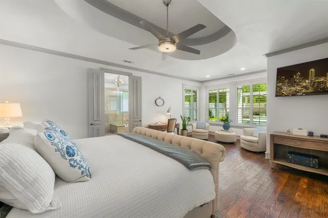 a bedroom with a bed a couch and large window