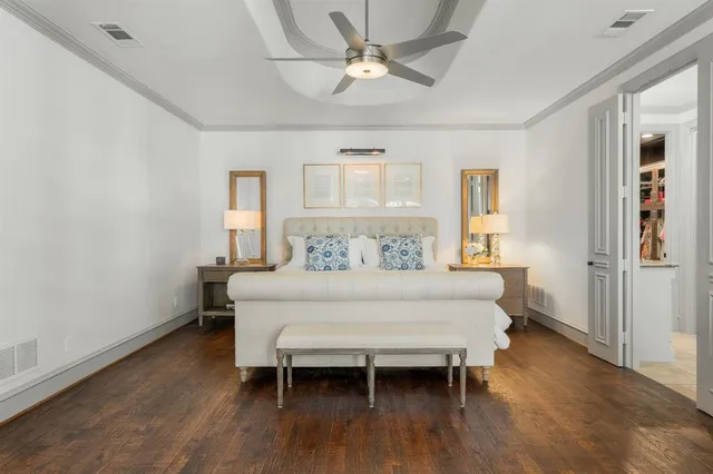 a bed sitting in a room next to a window and a chandelier