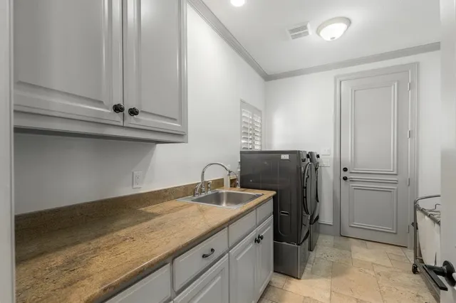 a bathroom with a granite countertop sink and washing machine