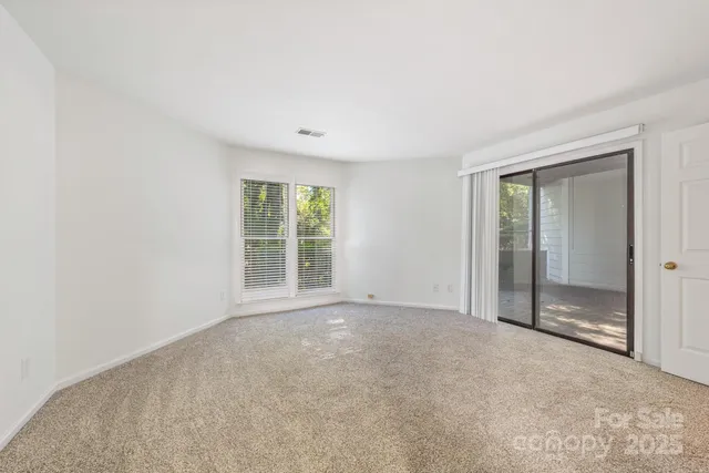 an empty room with sliding glass door and shower