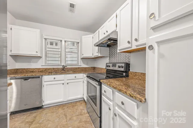 a kitchen with stainless steel appliances granite countertop a sink stove and cabinets
