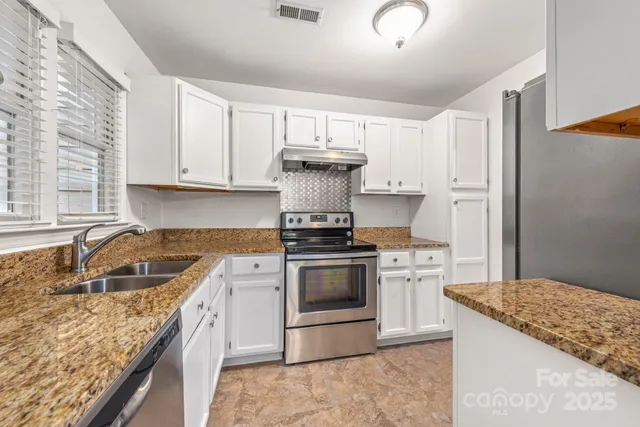 a kitchen with stainless steel appliances granite countertop a sink stove and refrigerator