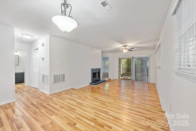 a view of a livingroom with wooden floor and a ceiling fan