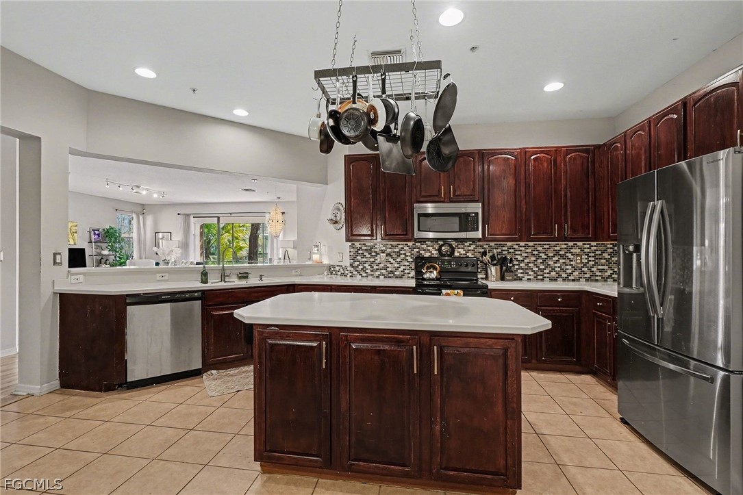 3799 Costa Maya Way, Unit 101 Estero, FL 33928 - Photo 12 of 35 a kitchen with stainless steel appliances granite countertop a sink a stove a refrigerator and a refrigerator