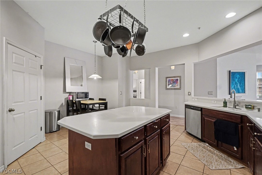3799 Costa Maya Way, Unit 101 Estero, FL 33928 - Photo 15 of 35 a kitchen with a kitchen island a sink stainless steel appliances and cabinets