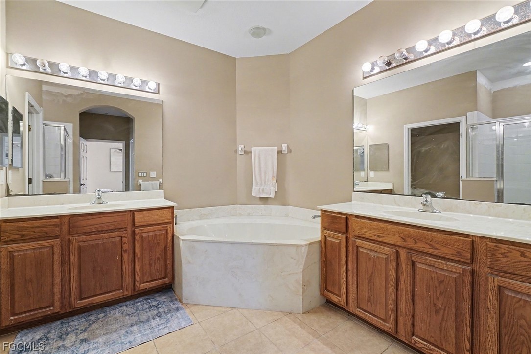 3799 Costa Maya Way, Unit 101 Estero, FL 33928 - Photo 18 of 35 a spacious bathroom with a double vanity sink a mirror and a