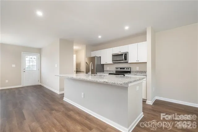 a kitchen with stainless steel appliances granite countertop a stove a sink and a microwave