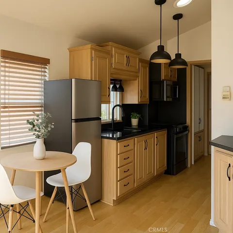 a kitchen with stainless steel appliances granite countertop a refrigerator a microwave a sink and a stove