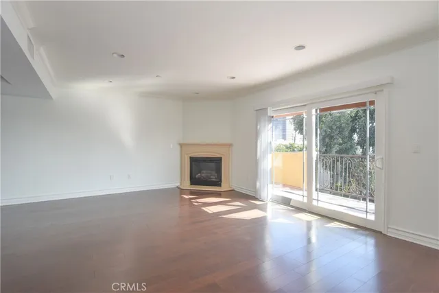 an empty room with wooden floor and a fireplace