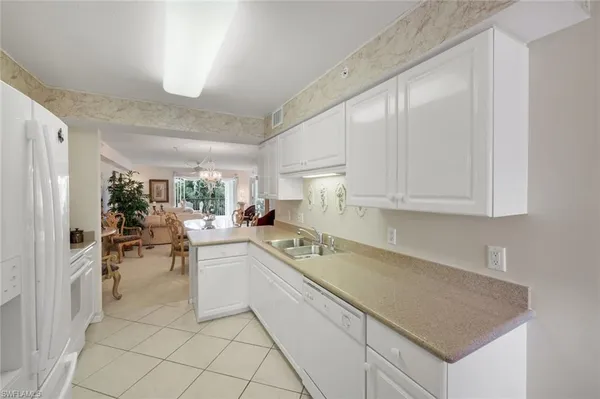 a kitchen with white cabinets and sink