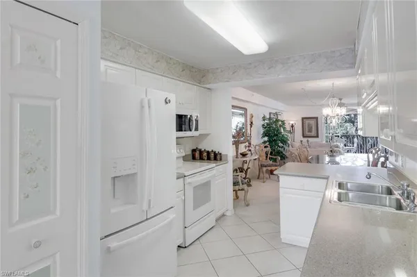 a kitchen with white cabinets and white appliances
