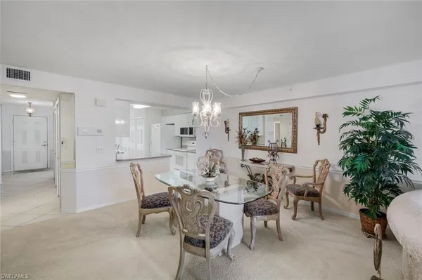 a view of a dining room with furniture and chandelier