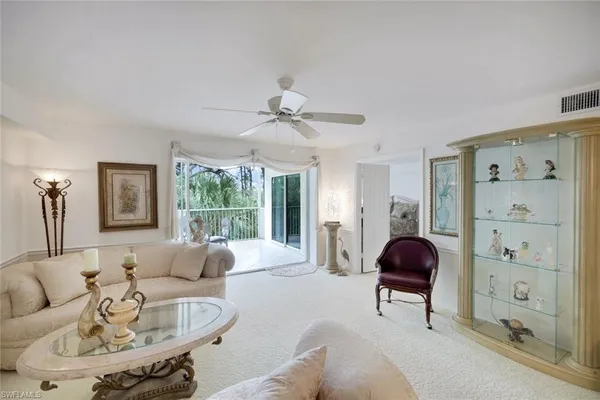 a living room with furniture a large window and a chandelier