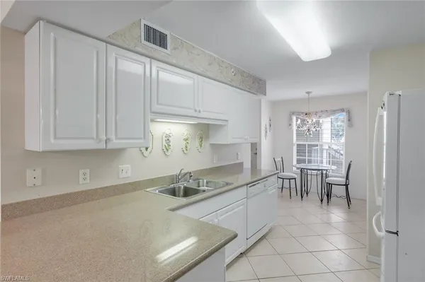 a kitchen with granite countertop a sink and white cabinets