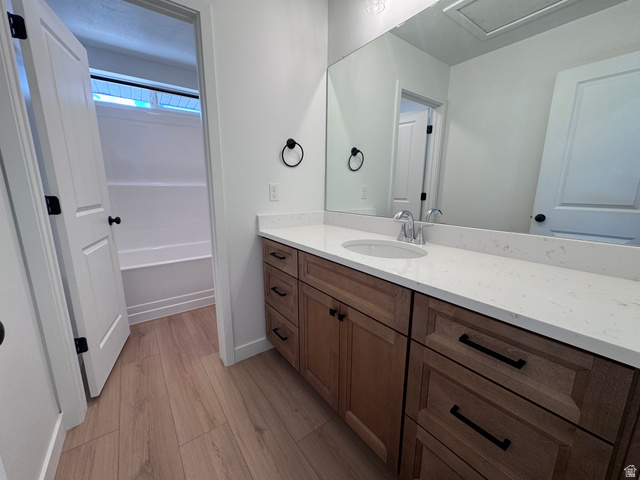 2613 Scarlet Road, Unit 258 Eagle Mountain, UT 84005 - Photo 20 of 33 Bathroom with wood-finish flooring, a long vanity with light-toned countertop, and an integrated sink with chrome faucet
