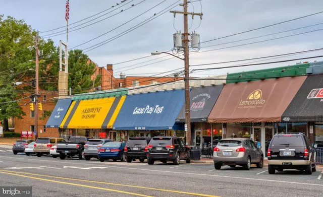 a group of people sitting in front of retail shops