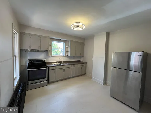 a kitchen with a refrigerator and a stove top oven