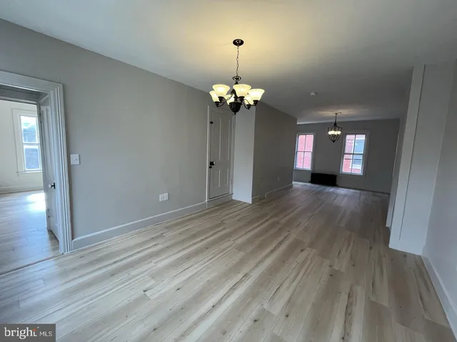 a view of a room with wooden floor and chandelier