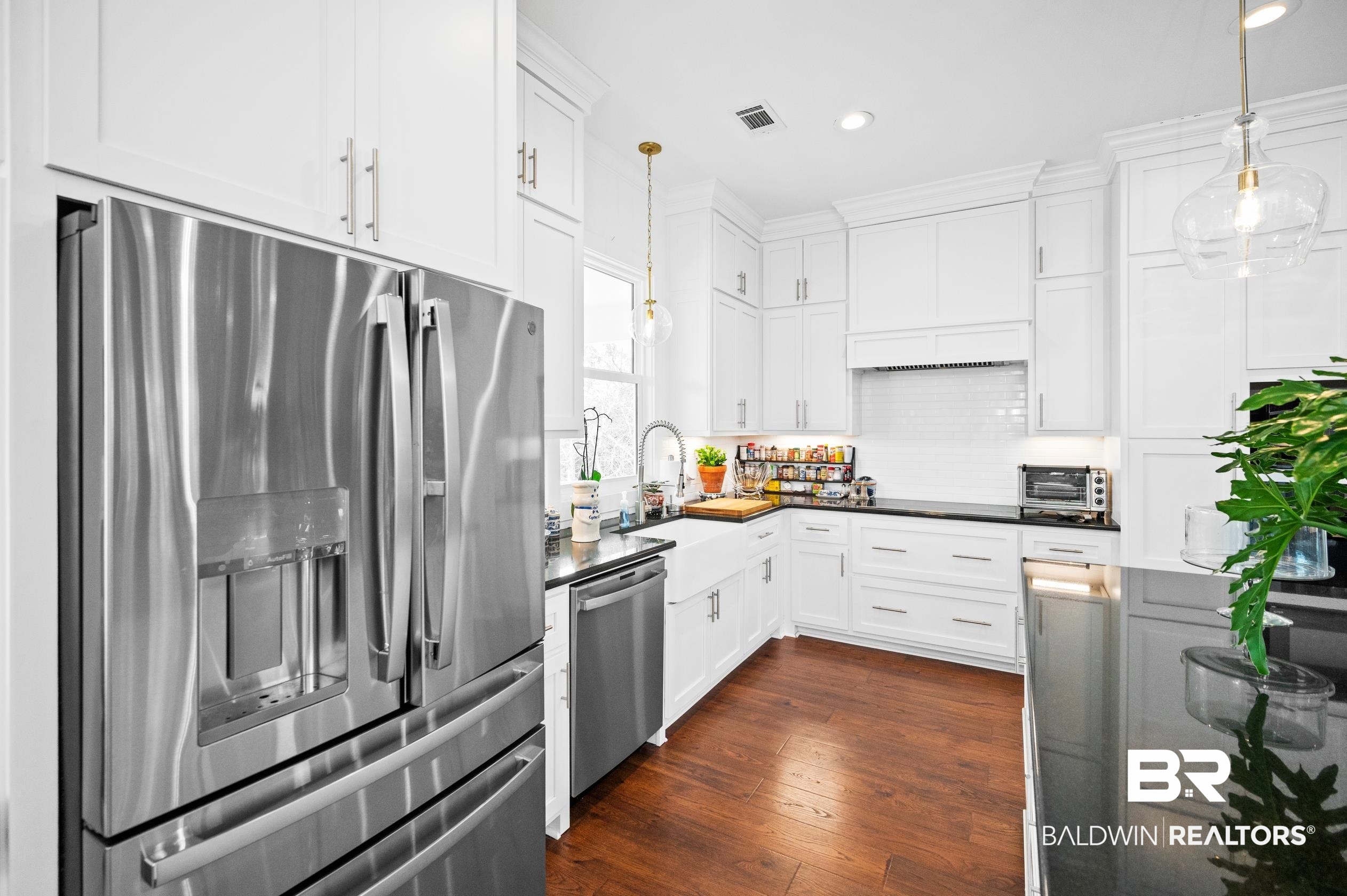 31835 River Road Orange Beach, AL 36561 - Photo 27 of 55 Kitchen with white cabinetry, sink, decorative light fixtures, and appliances with stainless steel finishes