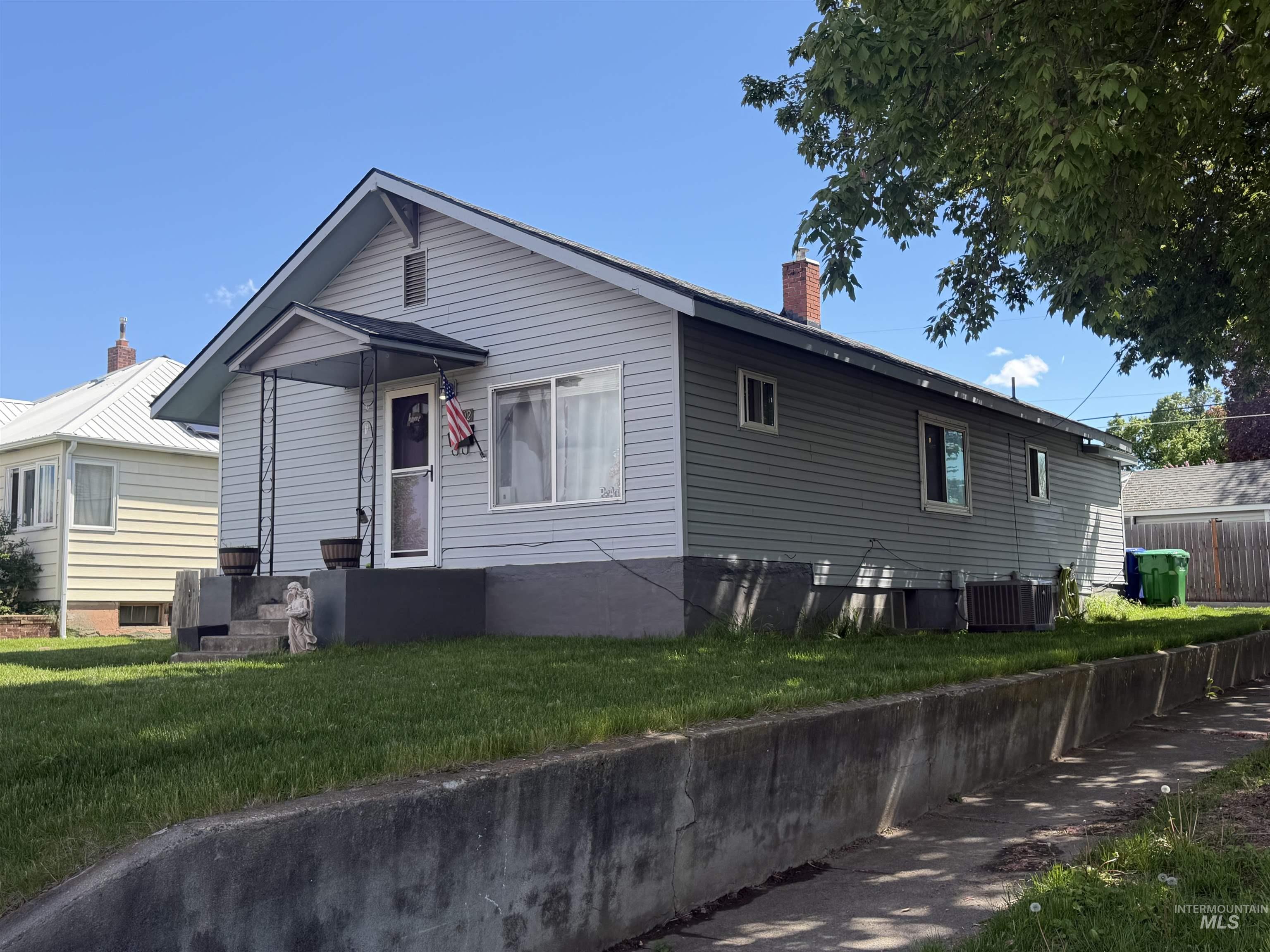1602 14th Avenue Lewiston, ID 83501 - Photo 1 of 32 Two-tone exterior siding in light gray and olive green, featuring a covered front entry with decorative metal supports