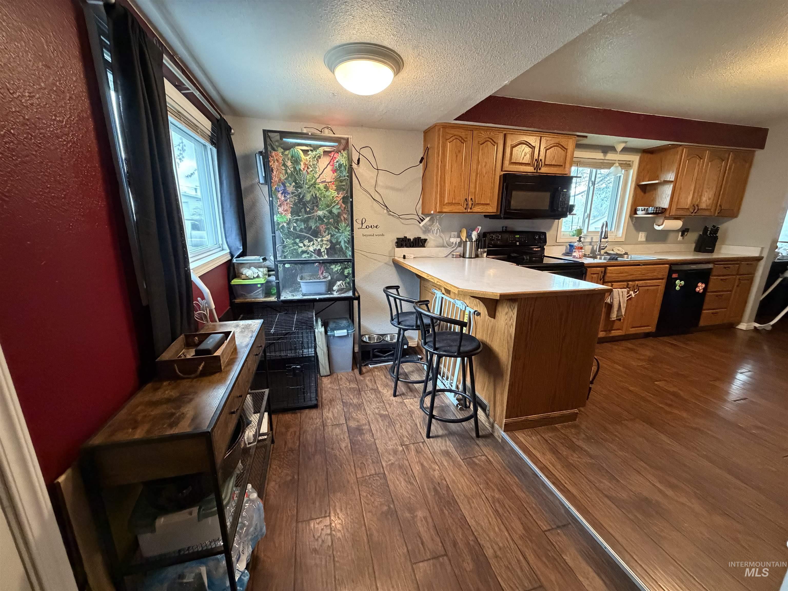 1602 14th Avenue Lewiston, ID 83501 - Photo 20 of 32 Kitchen with light countertops, a textured ceiling, dark wood-type flooring, wood finish cabinetry, and a peninsula