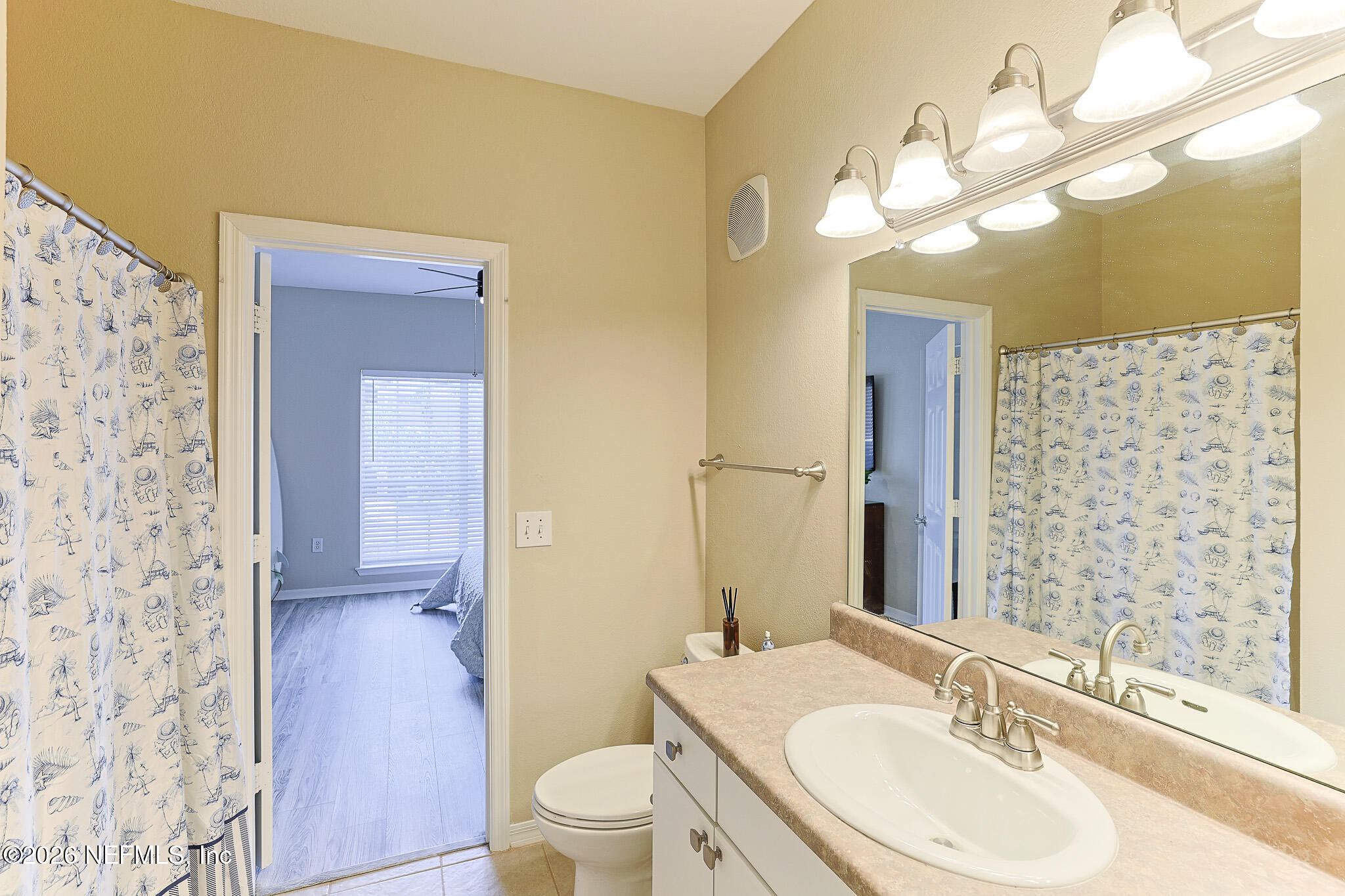 10961 Burnt Mill Road, Unit 426 Jacksonville, FL 32256 - Photo 11 of 24 a bathroom with a granite countertop sink toilet a mirror a vanity and shower