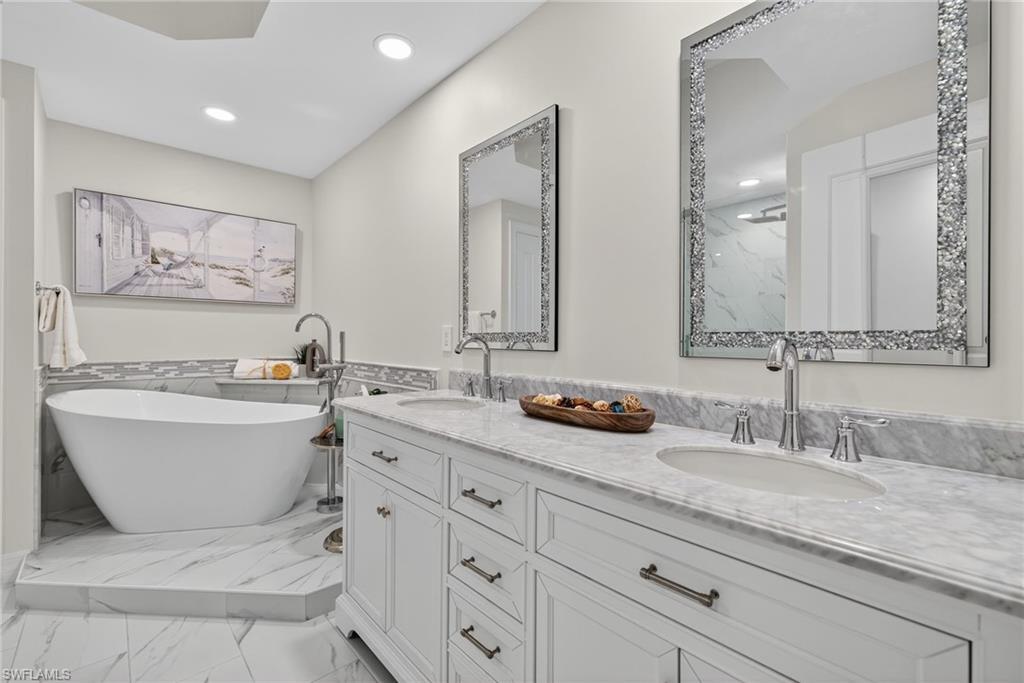 14380 Riva Del Lago Drive, Unit 802 Fort Myers, FL 33907 - Photo 20 of 49 a bathroom with a granite countertop sink mirror vanity bathtub and toilet
