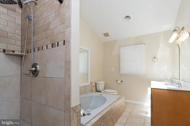 a bathroom with a tub sink and mirror