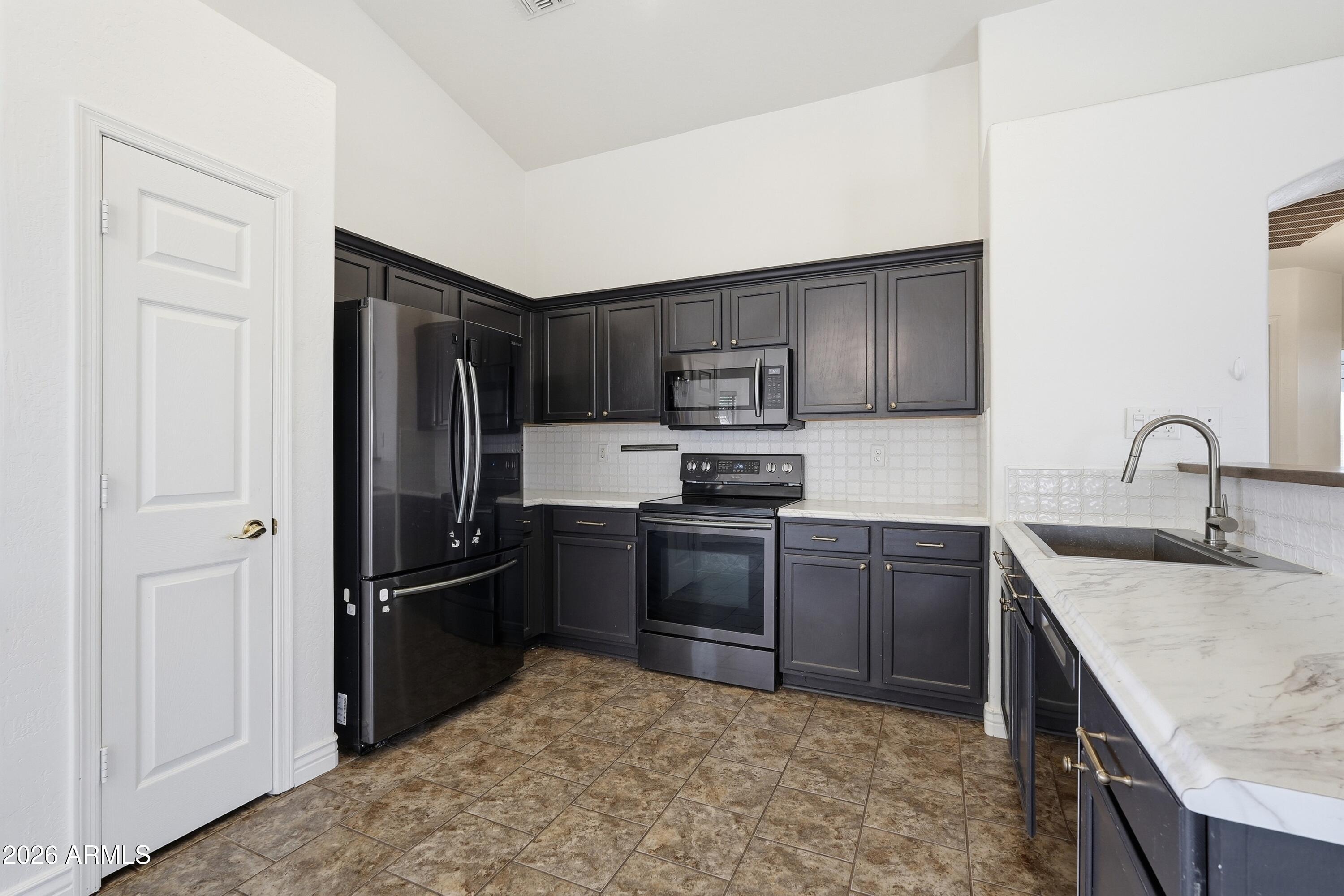 3242 East Bonanza Road Gilbert, AZ 85297 - Photo 5 of 36 a kitchen with a refrigerator stove and sink
