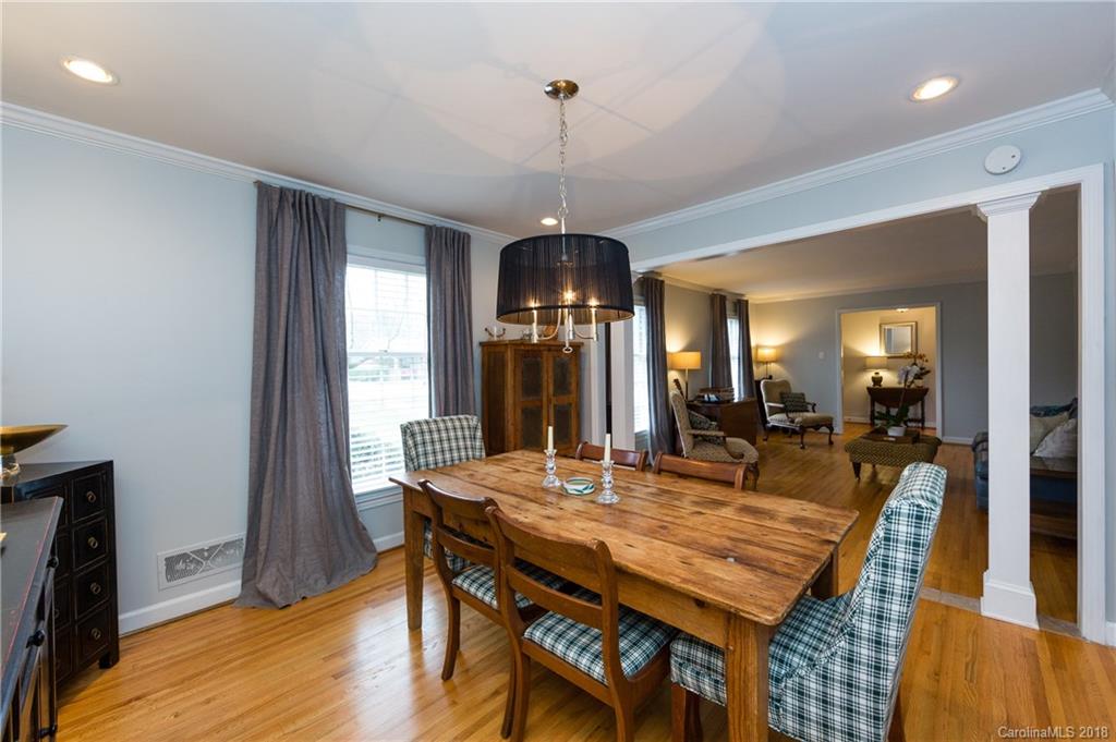 4615 Walker Road Charlotte, NC 28211 - Photo 8 of 28 a dining room with wooden floor a chandelier a wooden table and chairs
