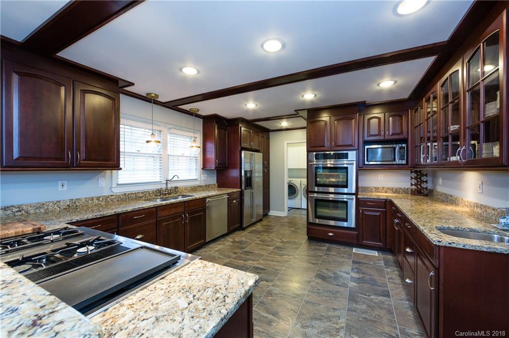 4615 Walker Road Charlotte, NC 28211 - Photo 10 of 28 a kitchen with stainless steel appliances granite countertop a stove refrigerator and cabinets