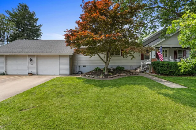 a view of a house with backyard and a tree