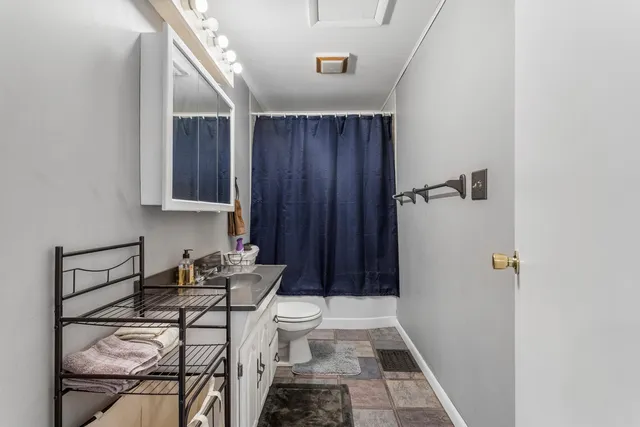 a bathroom with a sink a toilet a mirror and shower