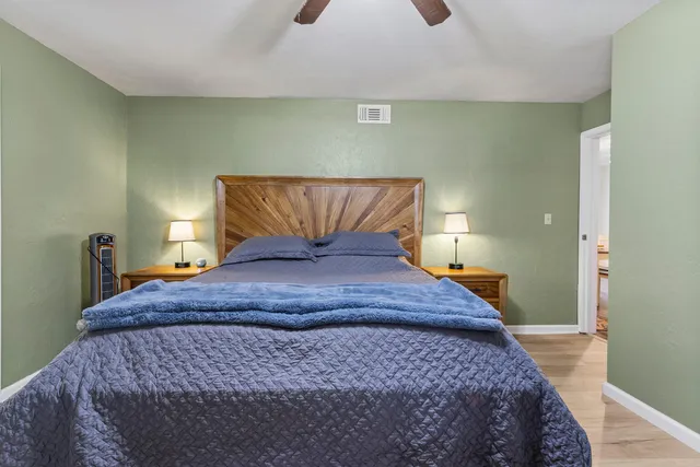 a bedroom with a bed and wooden floor