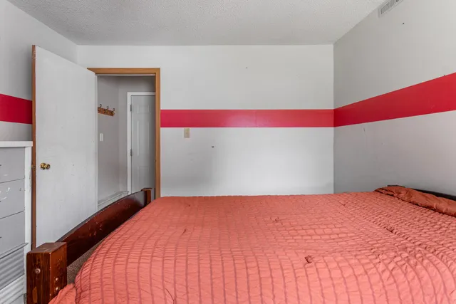 a bedroom with a bed and a mirror