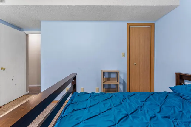 a view of a bedroom with wooden floor and bed