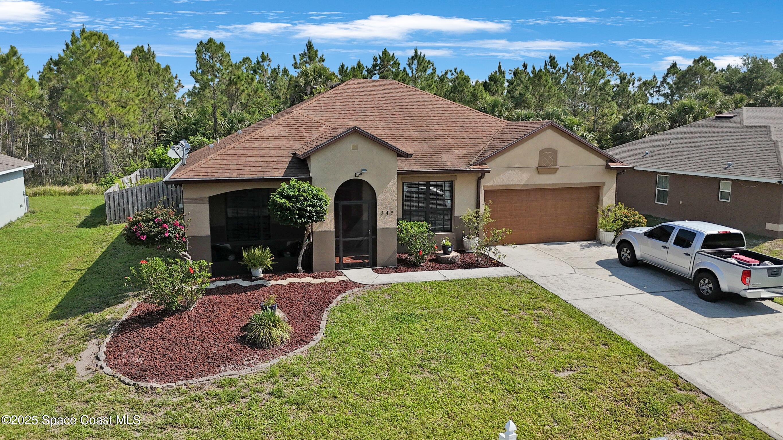 249 Franzing Street Palm Bay, FL 32908 - Photo 36 of 38 a view of a house with backyard sitting area and garden