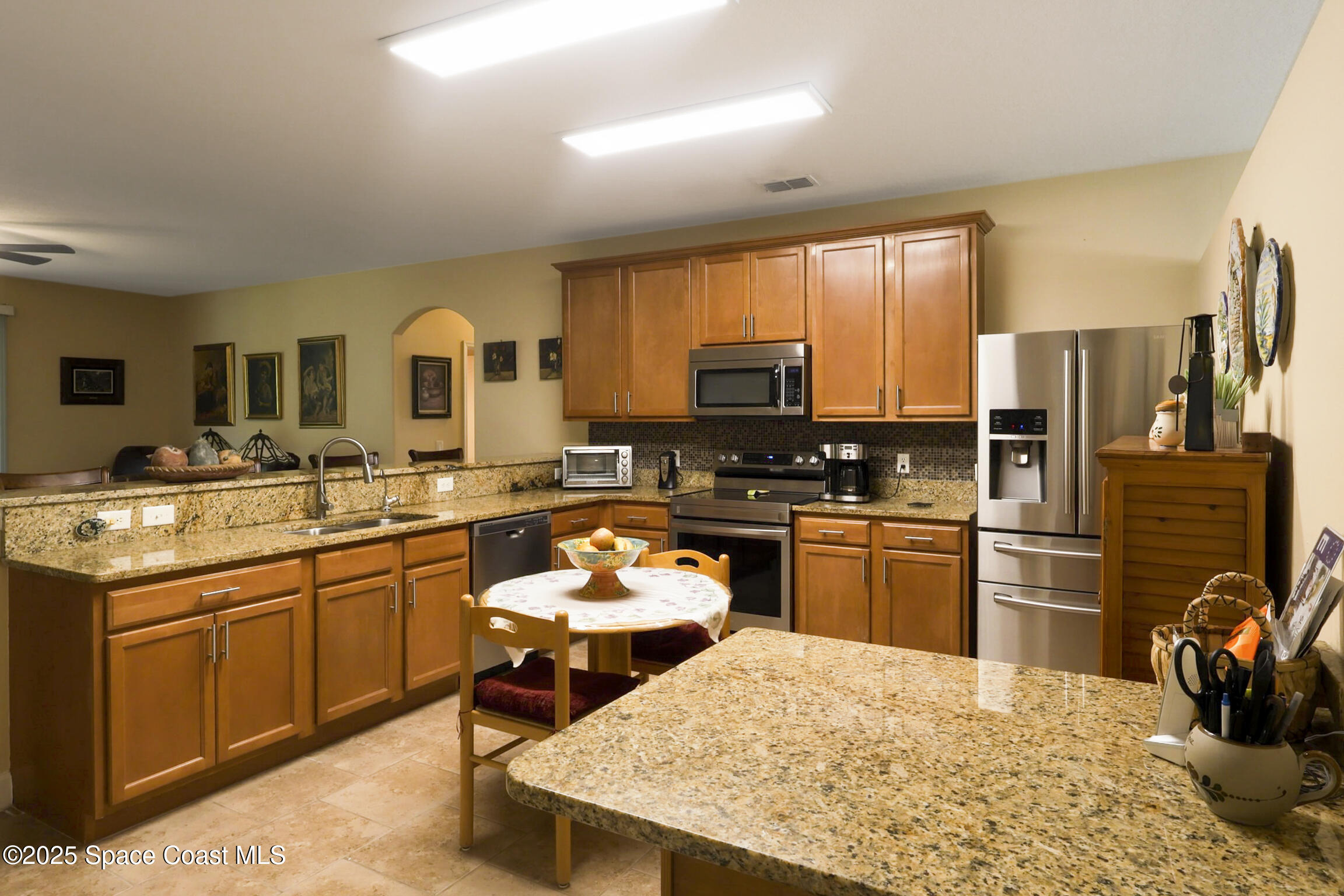 249 Franzing Street Palm Bay, FL 32908 - Photo 6 of 38 a kitchen with a sink refrigerator and microwave