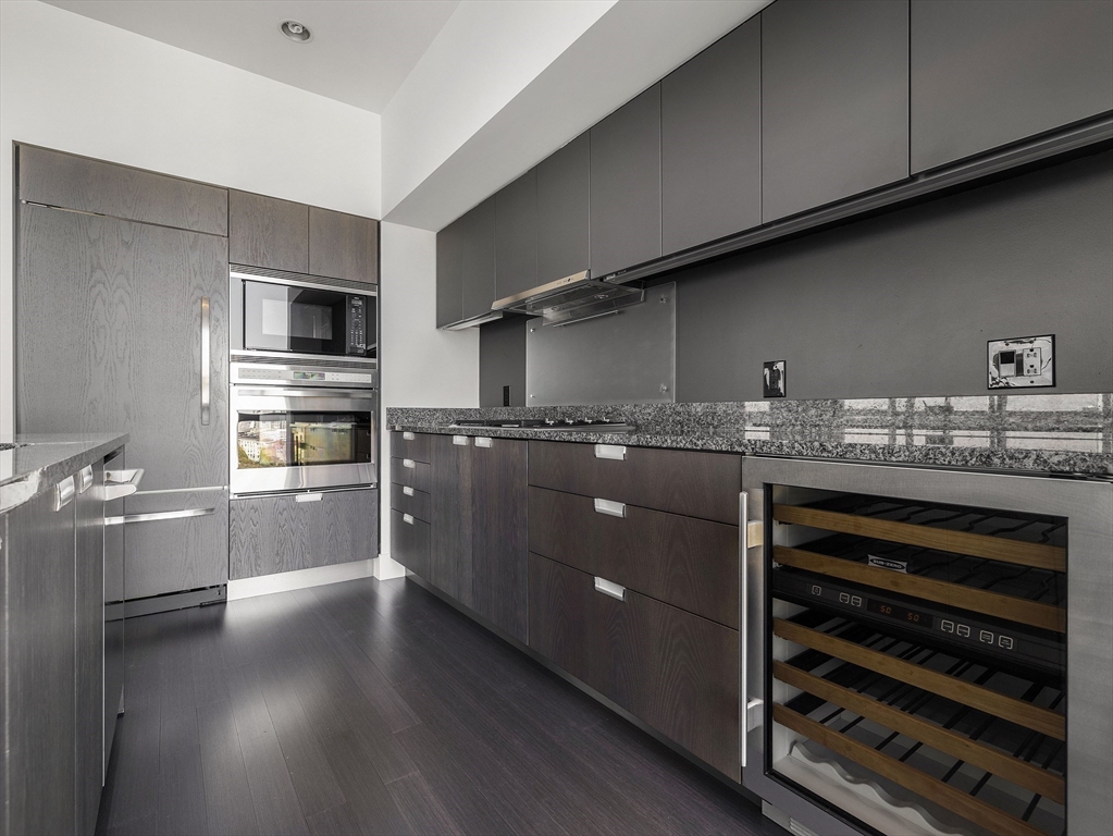110 Stuart Street, Unit 23G Boston, MA 02116 - Photo 12 of 39 a kitchen with stainless steel appliances kitchen island granite countertop a stove refrigerator and cabinets