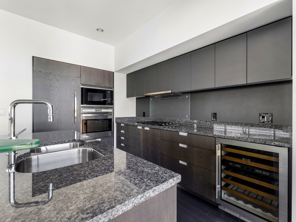 110 Stuart Street, Unit 23G Boston, MA 02116 - Photo 10 of 39 a kitchen with stainless steel appliances granite countertop a stove a sink and a microwave