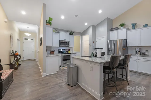 a kitchen with white cabinets and stainless steel appliances