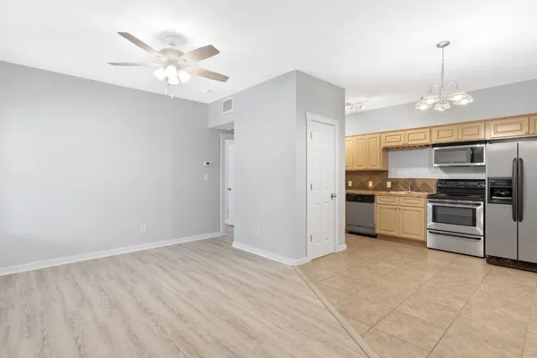 a view of kitchen with stainless steel appliances refrigerator stove microwave and cabinets