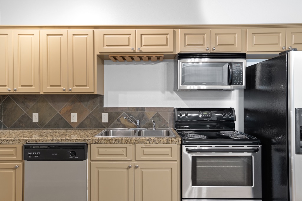 2106 Cullen Avenue, Unit 206 Austin, TX 78757 - Photo 7 of 15 a kitchen with stainless steel appliances granite countertop a stove and a microwave