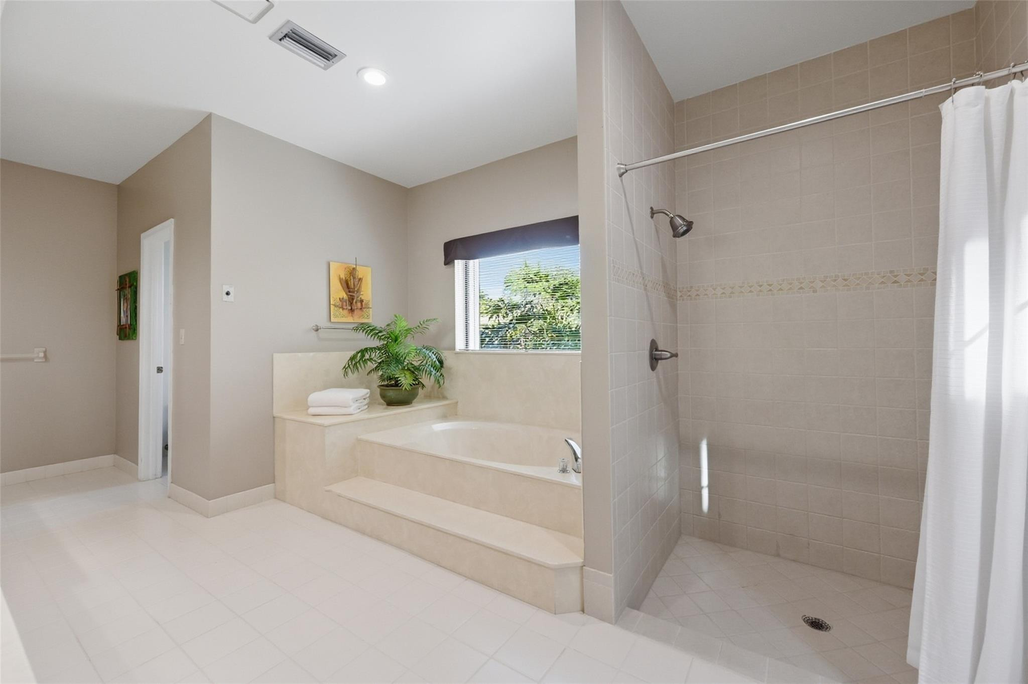 7720 West Upper Ridge Drive Parkland, FL 33067 - Photo 36 of 85 a white bath tub sitting in a en suite bathroom