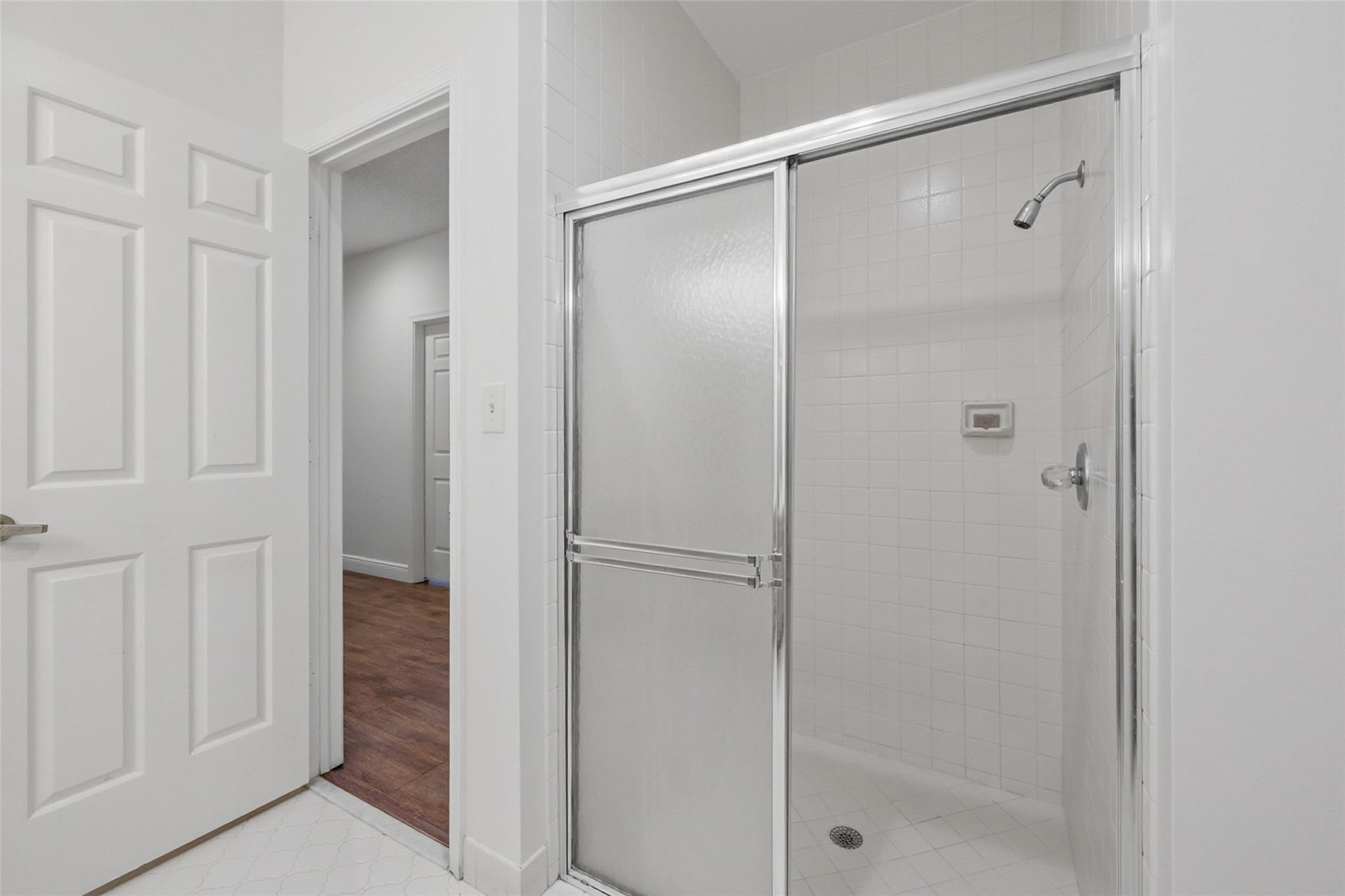 7720 West Upper Ridge Drive Parkland, FL 33067 - Photo 40 of 85 a bathroom with a glass shower door